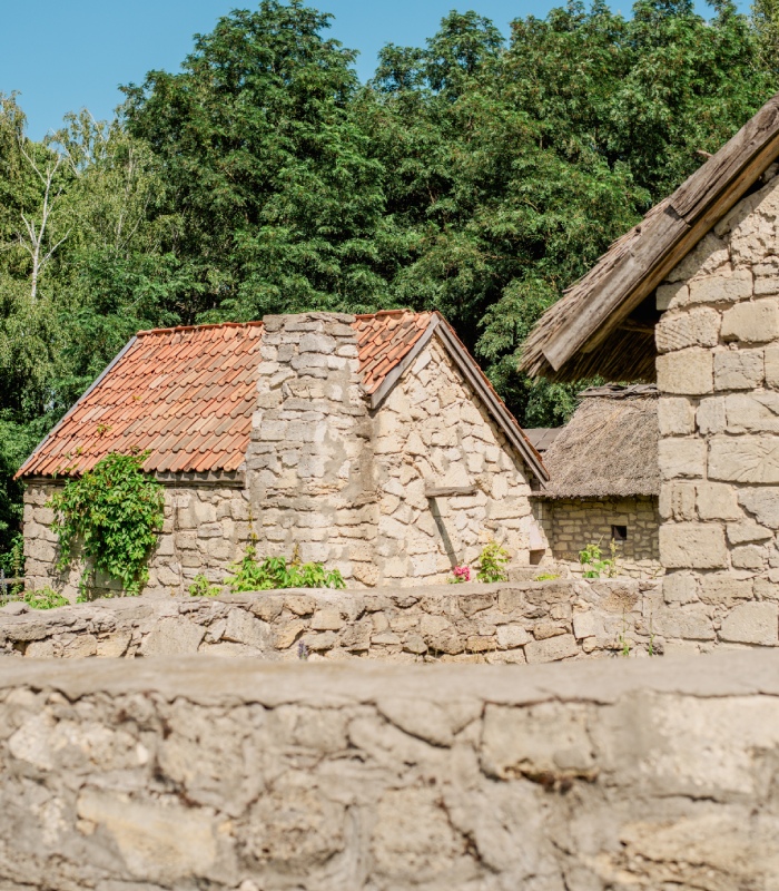 Maison ancienne en pierre avec toiture en tuiles et murs de clôture en maçonnerie